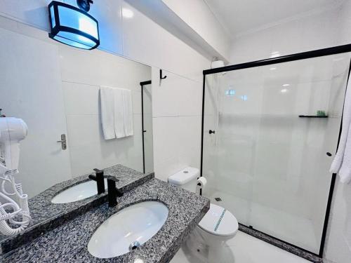 a bathroom with a sink and a toilet and a shower at Terrazas Hotel in Curitiba