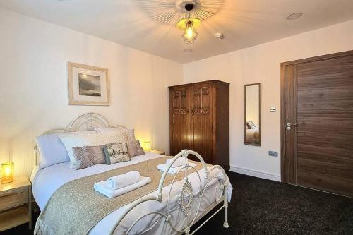 um quarto com uma cama branca e um armário de madeira em Central Buxton apt in Spring Gardens em Buxton