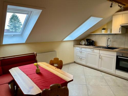 a kitchen with a table with a red table cloth at Gut Schwarz-n Hof Ferienwohnungen in Bad Griesbach