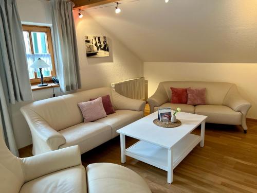 a living room with two couches and a table at Gut Schwarz-n Hof Ferienwohnungen in Bad Griesbach