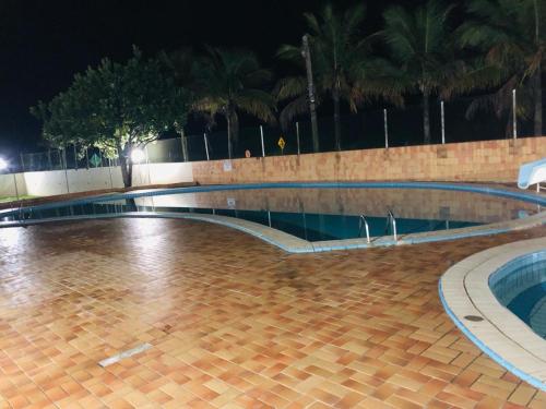 an empty swimming pool at night at Apartamento Aconchegante - Boraceia (Bertioga) in Bertioga