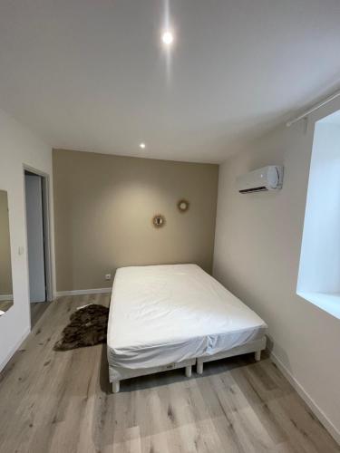 une chambre avec un lit blanc dans une pièce dans l'établissement Magnifique T2 entièrement rénové, à Le Teil