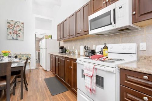 a kitchen with a white stove top oven next to a table at Great Kensington Market 2BR Apartment in Toronto