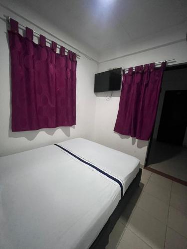 - une chambre avec un lit et des rideaux violets dans l'établissement Hotel Viva Villavicencio, à Villavicencio