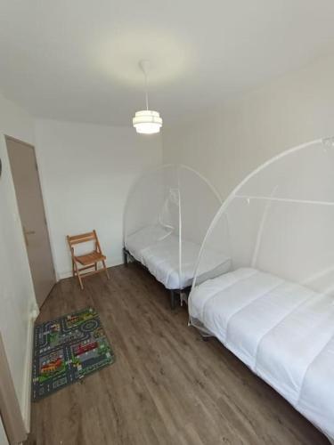 - 2 lits dans une chambre avec une table et une chaise dans l'établissement Joli T3 Cosy Netty proche Centre-Ville, à Sète