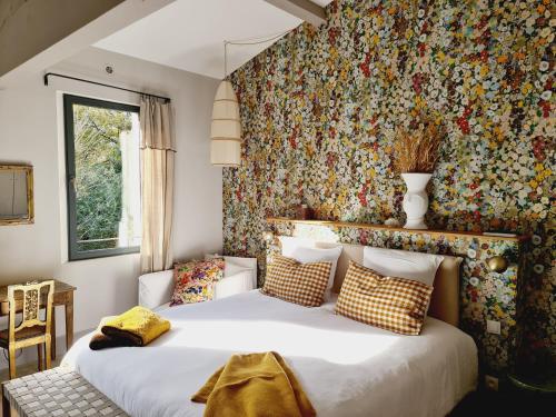 リル・シュル・ラ・ソルギュにあるLa Magnanerie de l'Isle B&Bの花柄の壁紙を用いたベッドルーム1室(大型ベッド1台付)