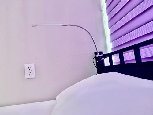 1 dormitorio con 1 cama con luz en la pared en Hostal Boutique de Venecia, en Ciudad de México