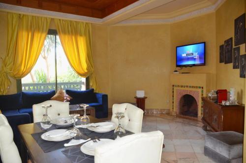 a living room with a table and a fireplace at Les Jardins de la palmeraie in Marrakech