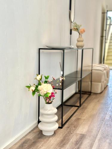 a vase filled with flowers sitting on the floor next to a table at Wohnen deluxe mit Pfänderblick in Bregenz