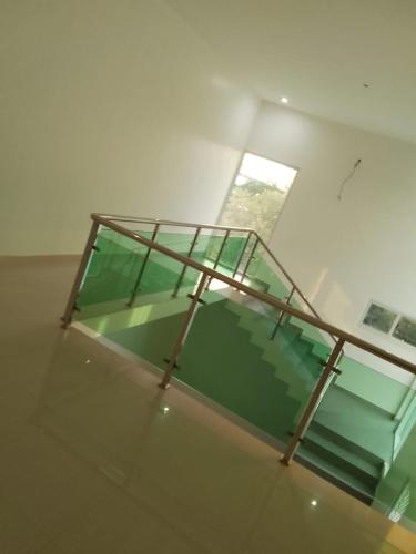 um quarto com um tecto de vidro com um corrimão de metal em Guest House Meg Alfa em Luanda