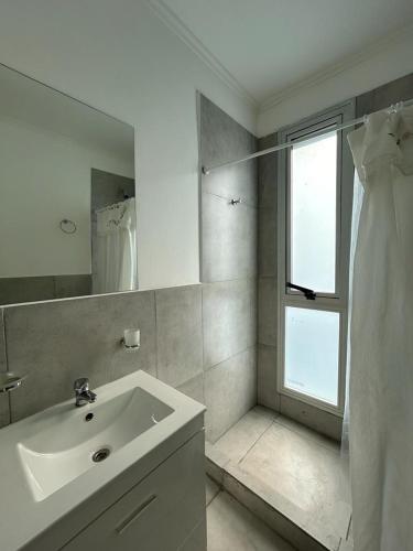 ein weißes Badezimmer mit Waschbecken und Fenster in der Unterkunft departamento céntrico y moderno in Gualeguaychú