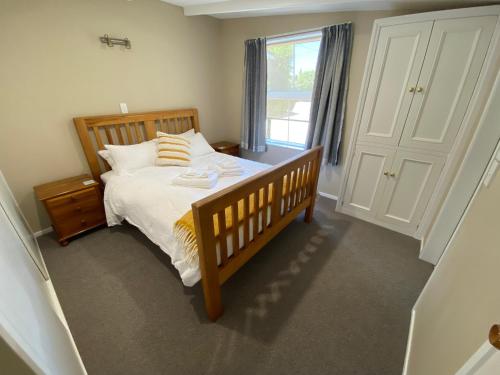 a bedroom with a large bed and a window at The cottage at the Gables in Motueka