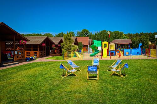 a group of lawn chairs and a playground at Domki Wypoczynkowe Letnia Przygoda in Mielno