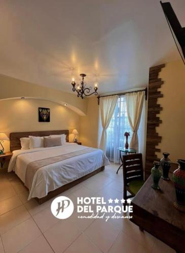 1 dormitorio con 1 cama grande y lámpara de araña en Hotel Del Parque en Huamantla