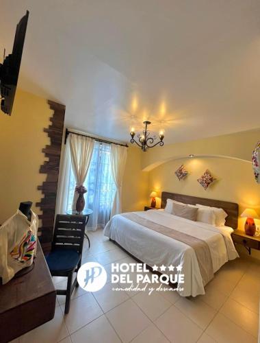 een slaapkamer met een groot bed en een kroonluchter bij Hotel Del Parque in Huamantla