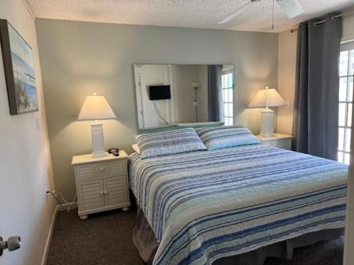 um quarto com uma cama e um espelho grande em Treasure Island Beach Club 727-360-7096 em St. Pete Beach