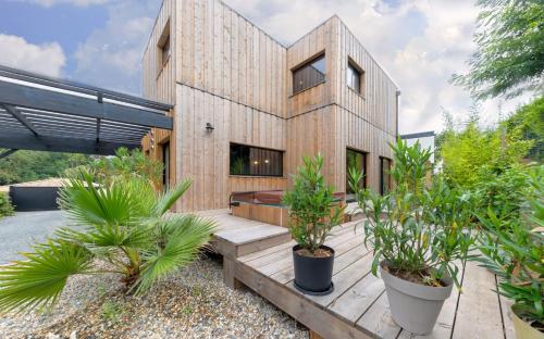 Magnifique villa bois à Lacanau port في لاكانو: منزل خشبي أمامه نباتات