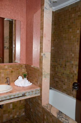 a bathroom with a sink and a mirror at Les Jardins de la palmeraie in Marrakech