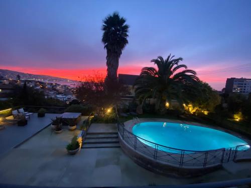 una piscina en la azotea de un edificio al atardecer en Hotel Boutique Casa Recreo, en Viña del Mar