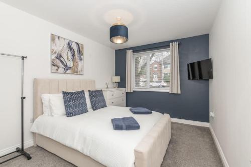 een slaapkamer met een wit bed en een raam bij Stylish & Modern 2 Bed 2 Bath With Free Parking in Leeds