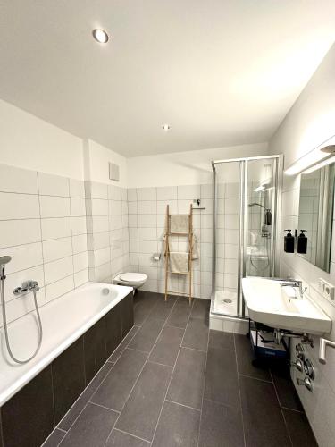 y baño con bañera, aseo y lavamanos. en Wohnen deluxe mit Pfänderblick en Bregenz