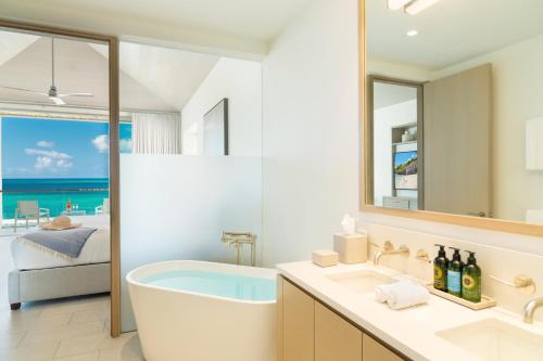 a bathroom with a tub and a view of the ocean at Rock House in Providenciales