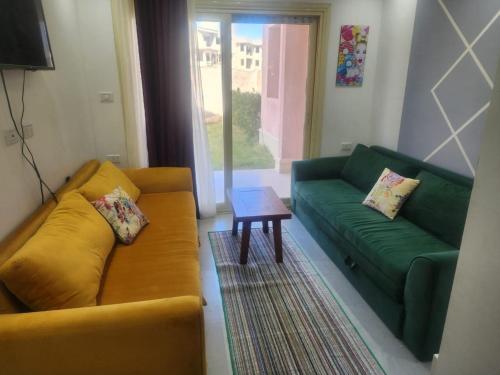 ein Wohnzimmer mit 2 grünen Sofas und einem Tisch in der Unterkunft بورتو مطروح الهاني in Marsa Matruh