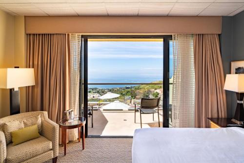 マリブにあるVilla Graziadio Executive Center at Pepperdine Universityのベッド付きのホテルルームで、パティオの景色を望めます。