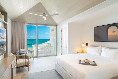 a bedroom with a bed and a view of the ocean at Rock House in Providenciales