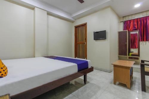 a bedroom with a bed and a tv in it at Thangam Lodge in Coimbatore