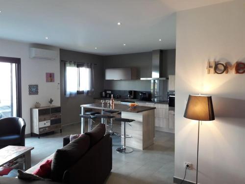 une cuisine et un salon avec un canapé et une table dans l'établissement Tout confort pour explorer la Haute Corse, à Olmeta-di-Tuda