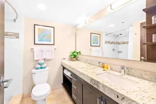 een badkamer met een wastafel, een toilet en een spiegel bij Modern Luxury Large Studio in Honolulu