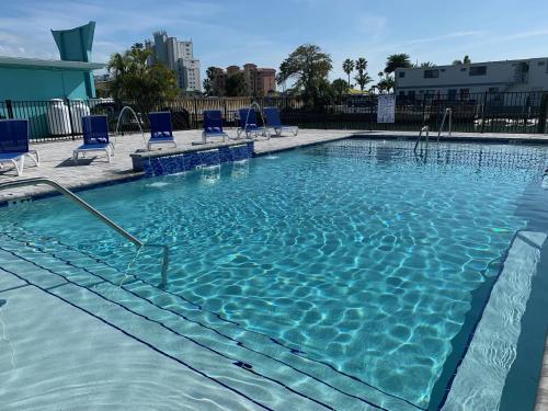 a large swimming pool with blue chairs in it at Sea Jay Motel and Marina in St Pete Beach