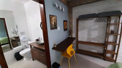a bathroom with a sink and a toilet and a mirror at Pousada Casa da Maga - Centro in Blumenau
