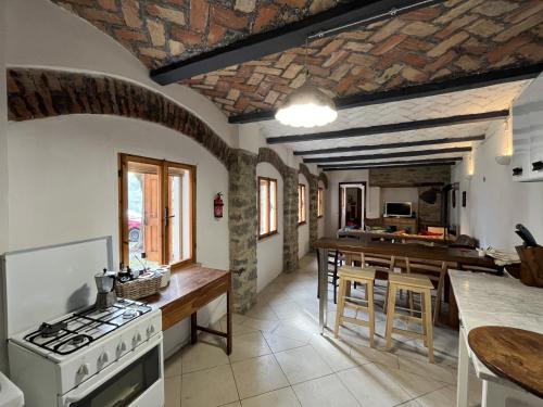 una cucina con piano cottura e tavolo con sedie di Casa Vigneto - Villa with pool a Toano