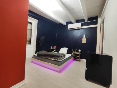 1 dormitorio con 1 cama con luces moradas en una habitación en jolie petite maison de bourg en Sayat