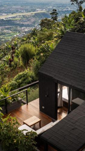 a wooden deck with a table and bench on a hill at Selva Negra Cabins in Pereira