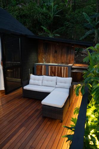 a couch sitting on a wooden deck at Selva Negra Cabins in Pereira