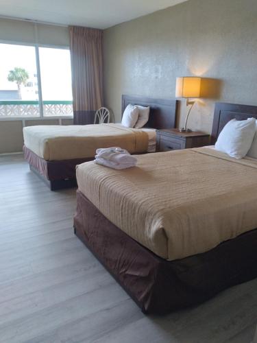 um quarto de hotel com duas camas e uma janela em The Virginian Motel em Myrtle Beach