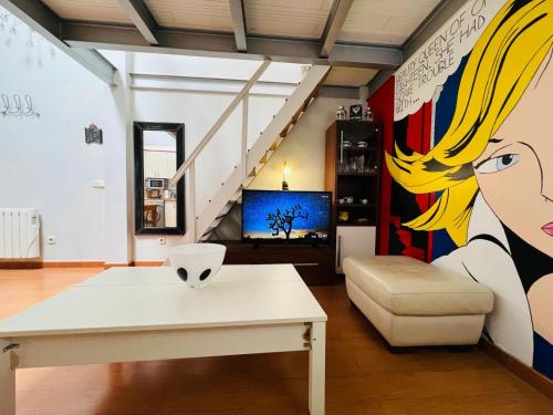a living room with a white table and a staircase at Palafox in Madrid