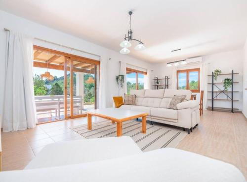 a living room with a white couch and a table at Villa Sa Planeta in Sant Josep de Sa Talaia