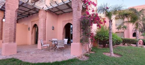 a patio with a table and chairs in a building at Les Jardins de la palmeraie in Marrakech