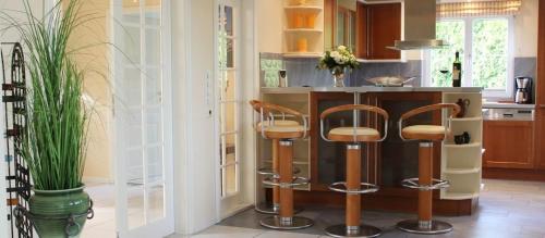 a kitchen with two bar stools and a counter at Villa Recknitztal Marlow in Marlow
