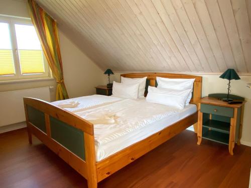 łóżko z białą pościelą i poduszkami w pokoju w obiekcie Villa Recknitztal Marlow w mieście Marlow