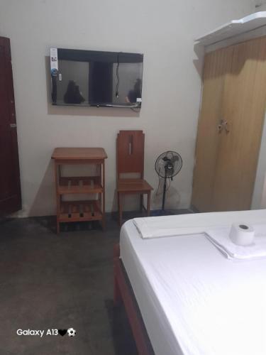 a bedroom with a bed and a table and a chair at HOSPEDAJE BUENA VISTA IQUITOS in Iquitos