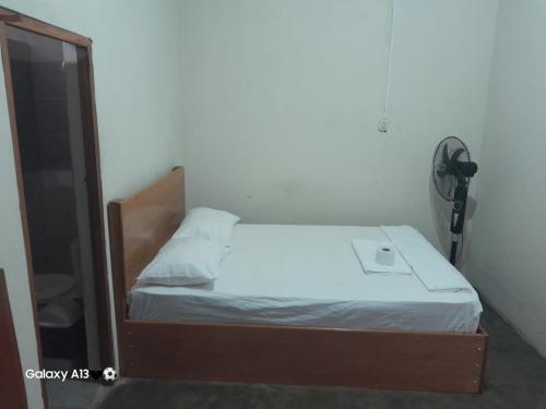 - une petite chambre avec un lit et un miroir dans l'établissement HOSPEDAJE BUENA VISTA IQUITOS, à Iquitos