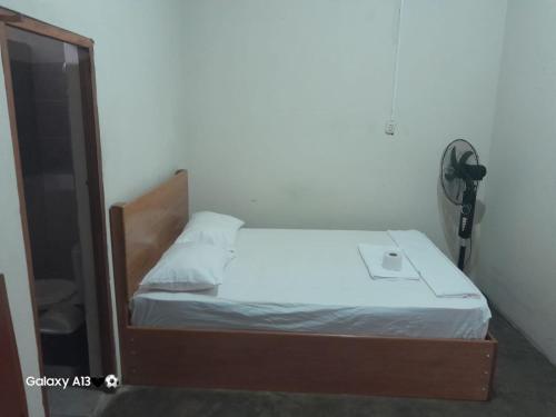 a small bedroom with a bed with a mirror at HOSPEDAJE BUENA VISTA IQUITOS in Iquitos