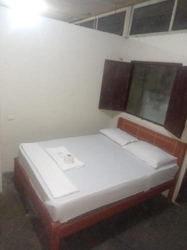 a bed in a room with a white wall at HOSPEDAJE BUENA VISTA IQUITOS in Iquitos