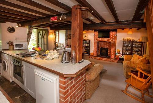 a kitchen with a counter and a living room at Strongate Cottage Rural Retreat - near Bridport & Jurassic Coastline in Netherbury