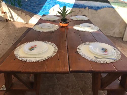 a wooden table with plates and napkins on it at Casa Sicilia Bedda in Aci SantʼAntonio